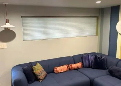 Blue sectional sofa with colorful pillows in modern living room design.