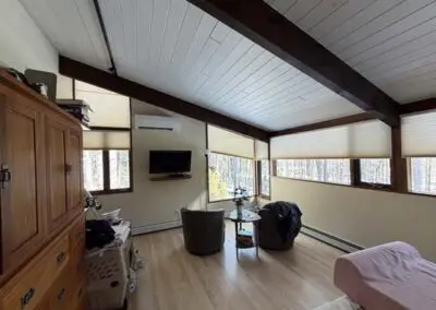 Cozy living room with vaulted ceiling, large windows, modern furniture.
