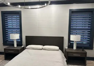Modern bedroom design with dark wood furniture and stylish lighting fixtures.